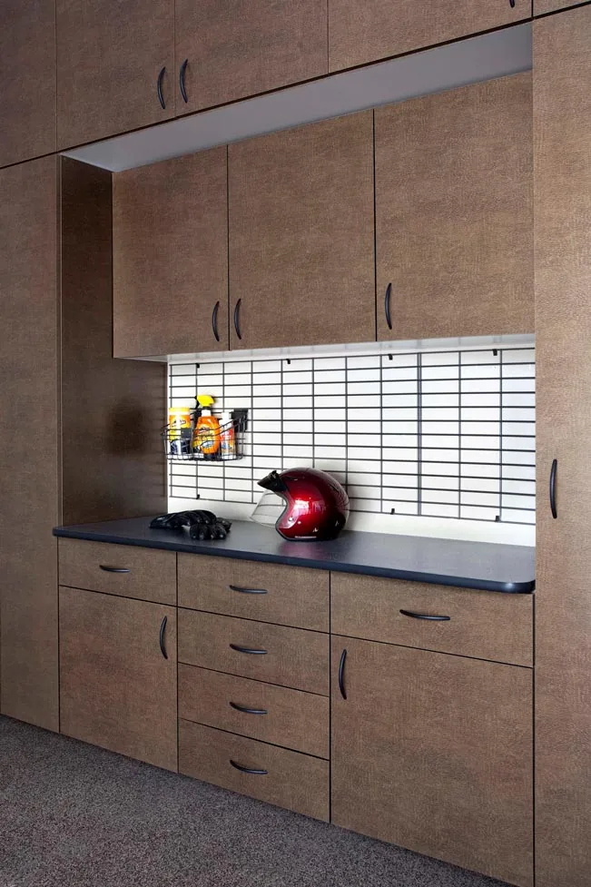 Custom bronze-finish garage storage cabinets with built-in workbench