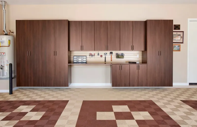Custom coco-finish garage storage cabinets with built-in workbench and pegboard tool wall