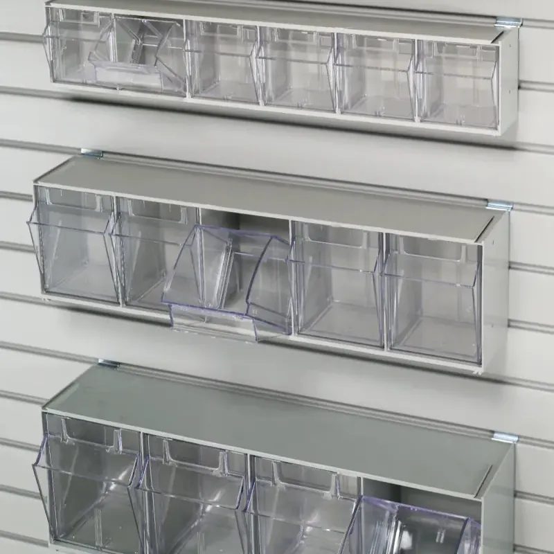 Tilt-out storage bin mounted on a garage slatwall system