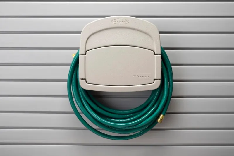 Wall-mounted garden hose holder for a garage slatwall system
