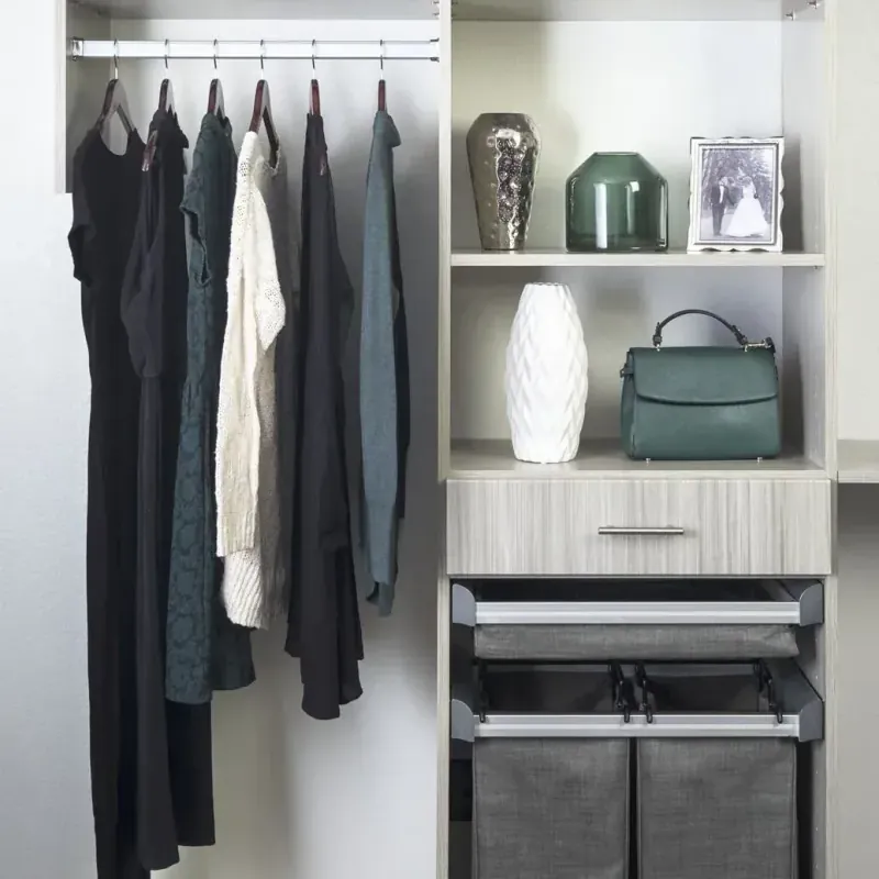 Reach-in closet with open hanging rail, display shelving and a handbag and vase display