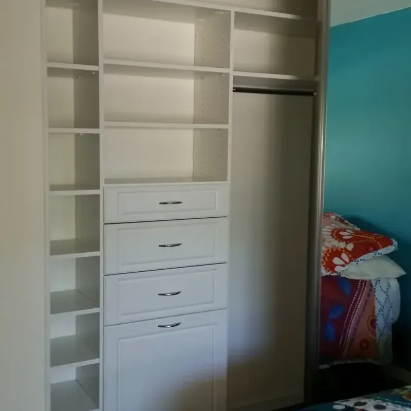 Reach-in closet with sliding mirror door and open shelving in a colorful bedroom