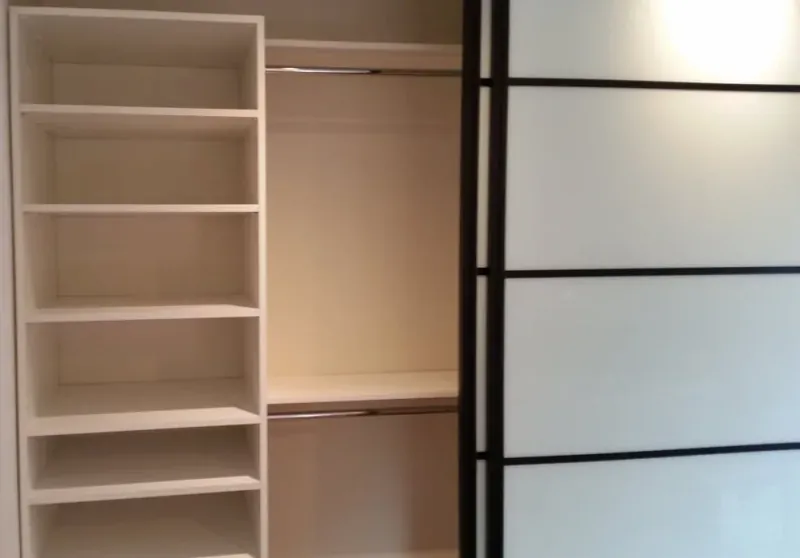 Reach-in closet with frosted glass sliding door and open shelving