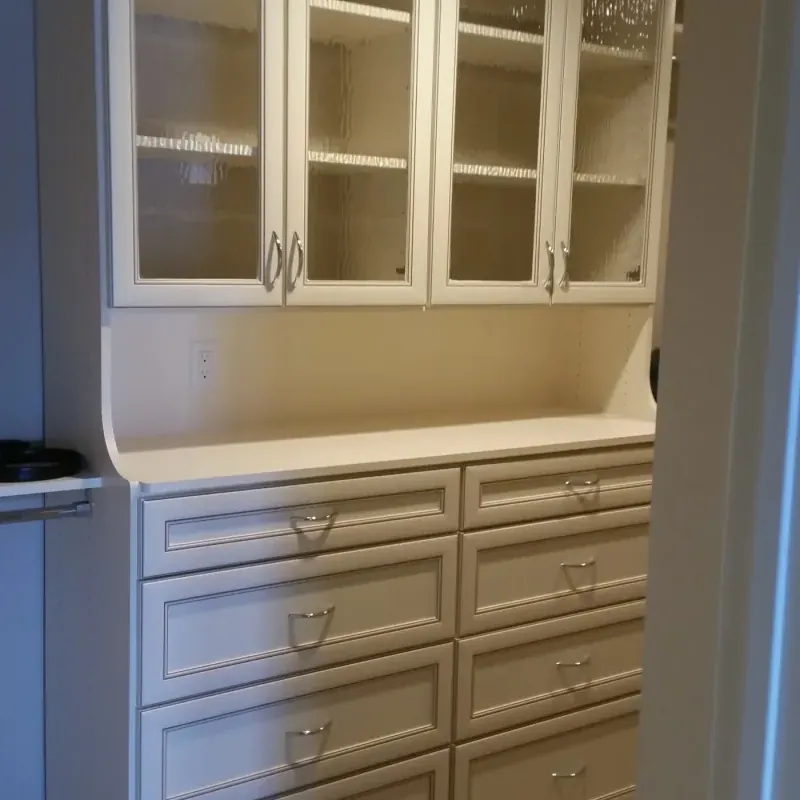 Walk-in closet with hanging storage and drawer stack