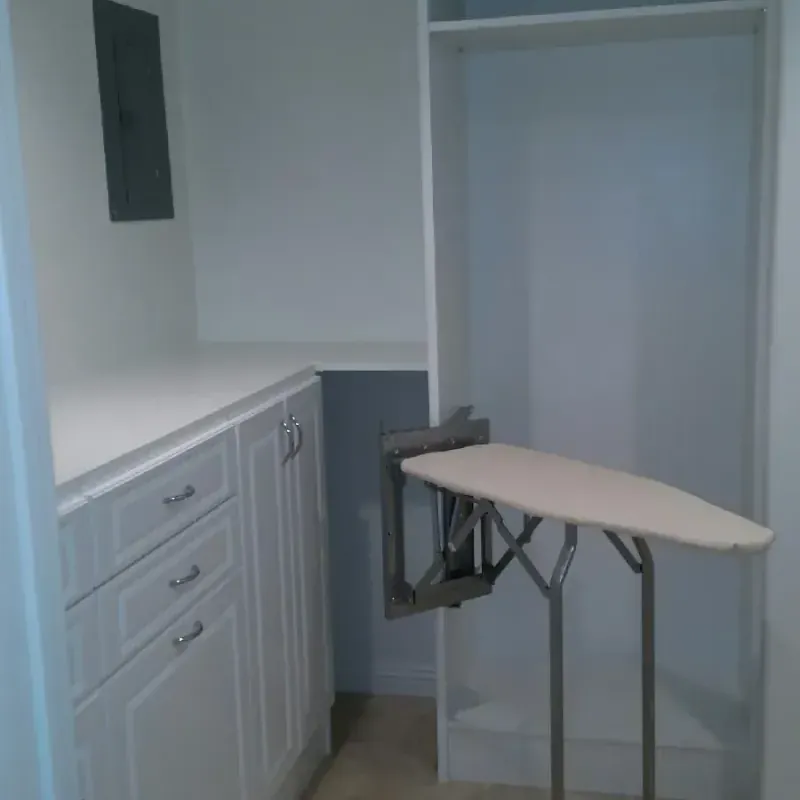 Laundry alcove with built-in cabinetry and fold-down ironing board