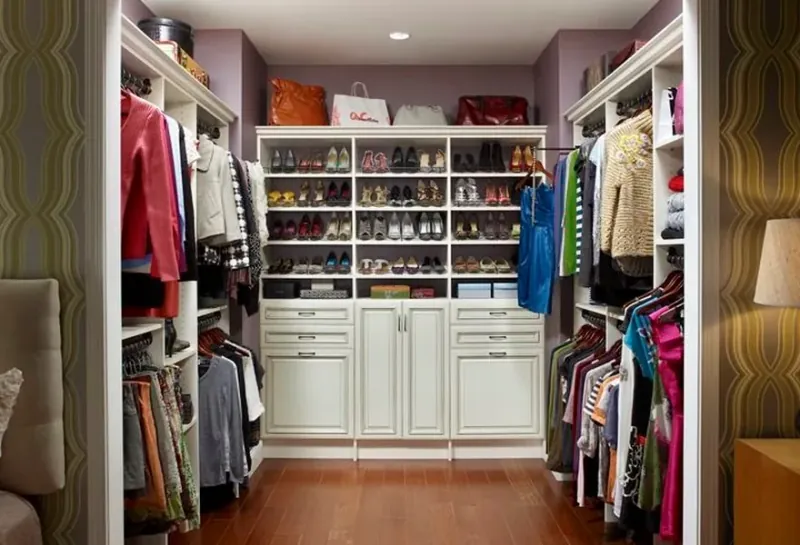 Boutique-style walk-in closet with shoe wall, handbag display and hanging storage
