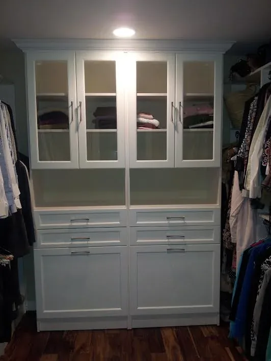 White walk-in closet with clear glass drawer fronts